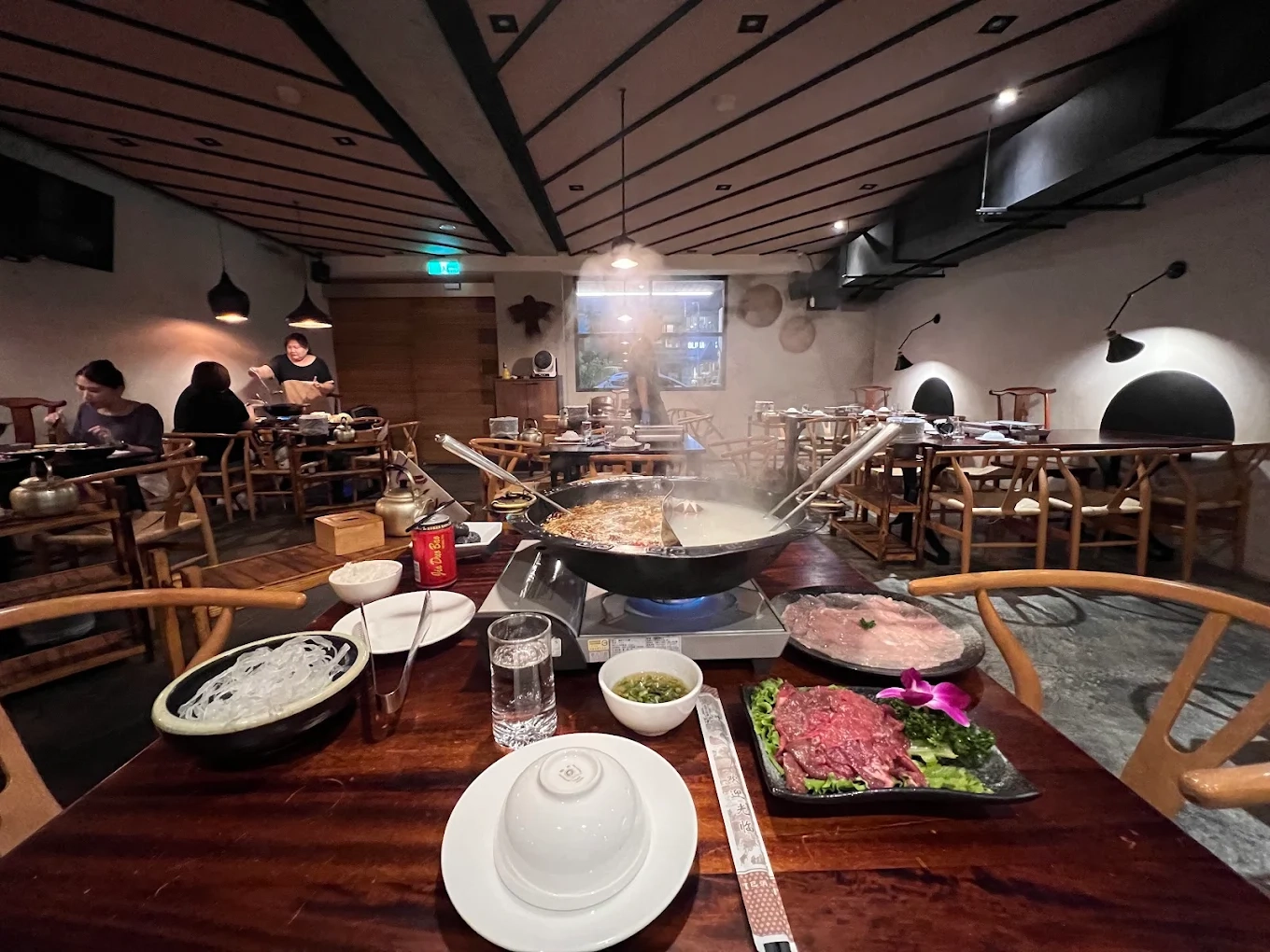 碼頭老火鍋溫馨店內環境，桌上擺滿新鮮牛肉與熱騰騰鴛鴦火鍋